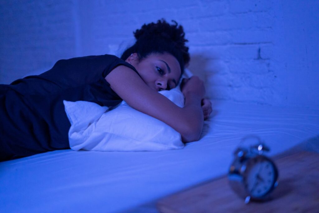 A woman lying in bed unable to sleep due to a toothache.